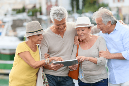 Group of retired couples looking a mobile devise